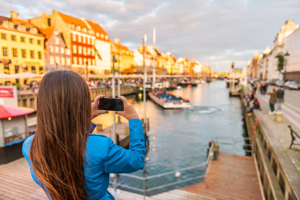 Kvinde som tager et foto i Nyhavn i København